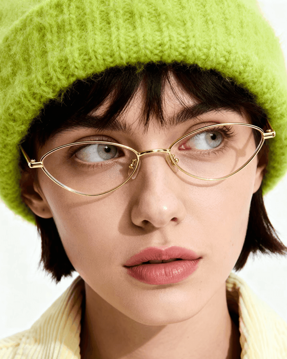 Woman in a lime knit beanie and gold glasses